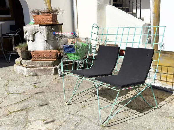 Metal tezgah ve taştan avluda alışveriş arabasıyla dışarıda oturmak..