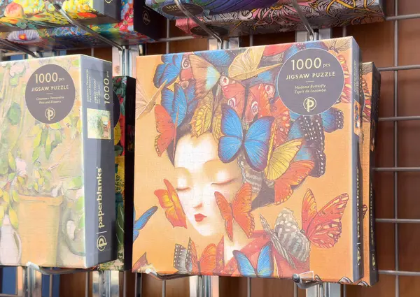 1000 parçalık yapboz, canlı bir kelebek ve rafta kadın resimleri var..