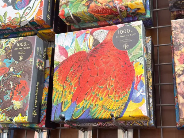 Raflarda gösterilen renkli papağan yapbozu.