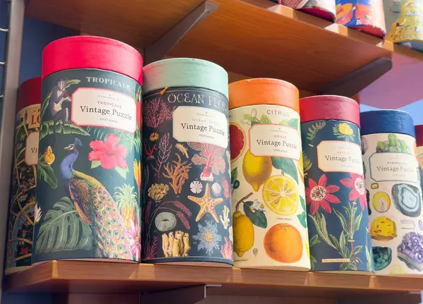 Bir mağazadaki raflarda renkli yapboz kutuları.