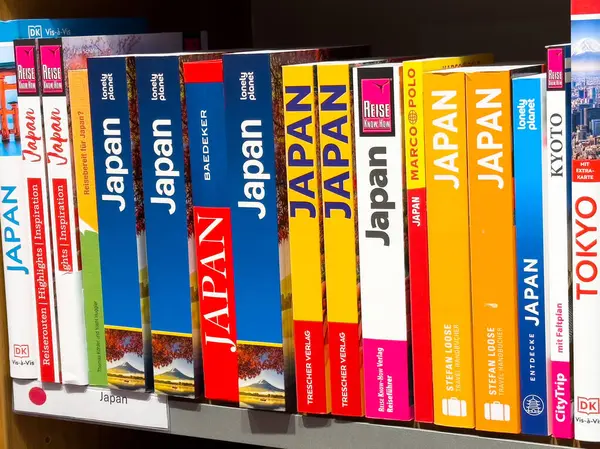 Çok çeşitli Japon seyahat rehberleri, canlı kapaklı bir rafta..