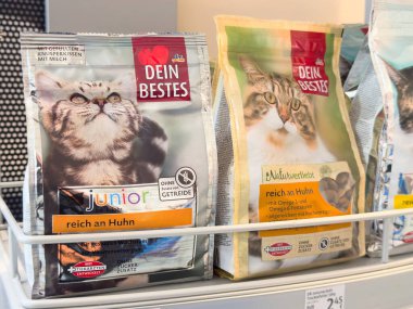 Süpermarkette tavuk aromalı genç ve yetişkin çeşitleri içeren kedi maması ambalajlama.