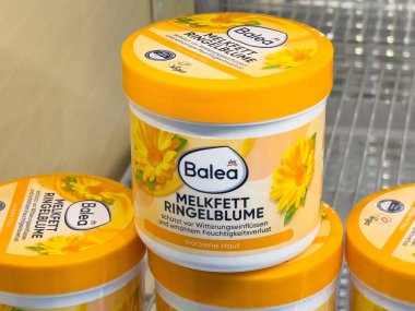 Balea melkfett ringelblume krema kavanozu ve rafta kadife çiçeği deseni var..