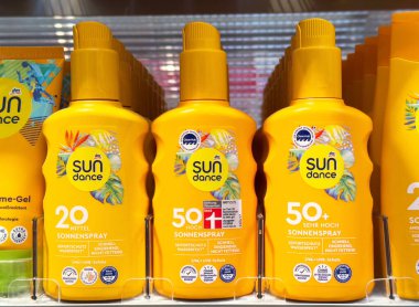 Güneş kremi şişeleri rafta spf varyasyonları ile görüntülenir.