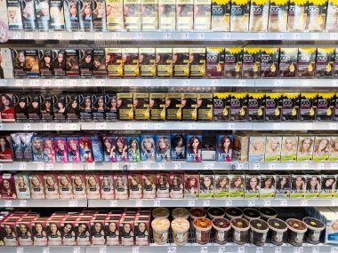 Mağaza raflarında gösterilen saç boyası ürünlerinin çeşitliliği.