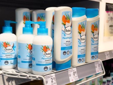 Rafta nemlendirici etiketli ve papaya tasarımlı balya saç bakım ürünleri var..