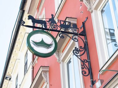 Şehir merkezindeki tarihi kırmızı binada antika taşıma tabelası.