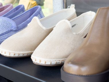 Bej rengi terlikler ve kahverengi deri ayakkabılar..