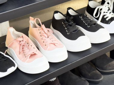 Pembe ve siyah raflarda moda platform spor ayakkabıları.