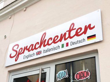 İngilizce, İtalyanca ve Almanca bayraklı Dil Merkezi tabelası.