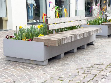 Çakıl taşı sokağında bahar çiçekleriyle dekoratif ekim bankları..