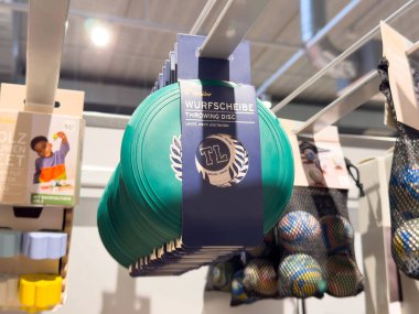 Arka planda oyuncaklar olan yeşil diskler mağazada sergileniyor.