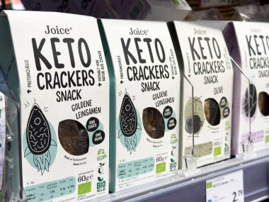 Çeşitli keto krakerleri besin etiketleriyle depolama rafında görüntülenir.