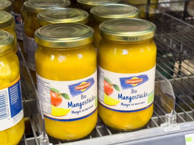 Vitrindeki cam kavanozlarda organik mango parçaları var..