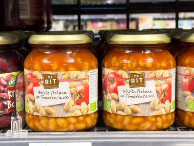 Domates sosu kavanozundaki organik beyaz fasulyeler süpermarketin rafında..