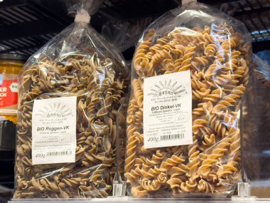 Organik kepekli çavdar ve raflarda fusilli makarna paketleri.