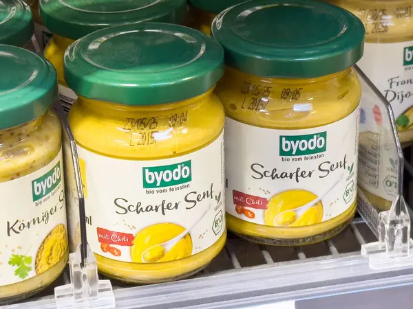 Baharatlı hardal kavanozları ve raflarda yeşil kapaklar..