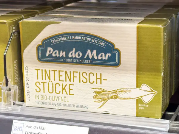 Pan mar kalamar parçalarını organik zeytinyağı ambalajına koyar..