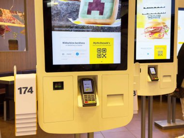 Fast food restoranında dijital ödeme seçeneğiyle self-servis büfesi.