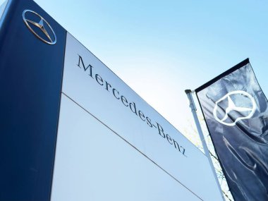 Mercedes-benz logosu ve bayrak açık mavi gökyüzü ile bayrak satış binası.