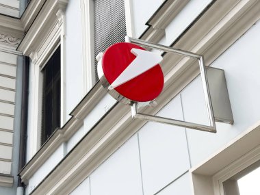 Kentsel yapı cephesinde modern kırmızı ve beyaz geometrik tabela.
