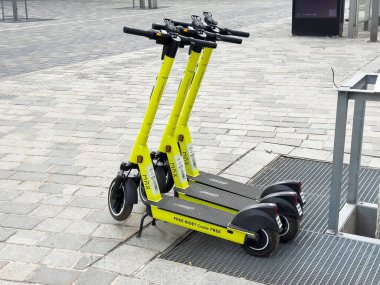 Şehir kaldırımında gezmek için parlak sarı elektrikli scooterlar..