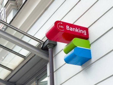 Şehir ortamında dış binanın üzerine renkli 24 saat bankacılık tabelası.