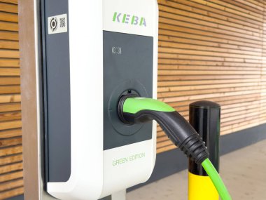 Fişi yeşil enerji kaynağına bağlı elektrikli araç şarj istasyonu.