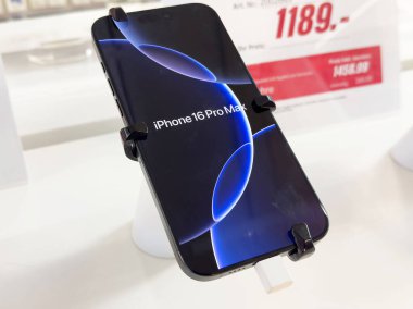 Yeni iphone 16 pro maksimum fiyat etiketli beyaz stantta sergileniyor.
