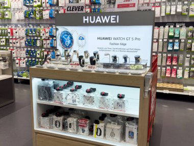 Huawei elektronik mağazasında çeşitli ukala aksesuarlarıyla gt 5 profesyonel vitrini izliyor..