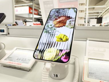 Elektronik mağaza kurulumunda canlı çiçek tasarımı gösteren akıllı telefon.