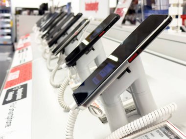 Elektronik mağazasında satılık yeni akıllı telefonlar sergileniyor.