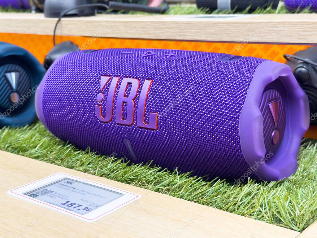 Purple jbl bluetooth speaker on display with price tag on artificial grass.