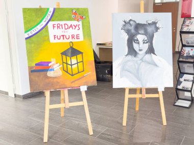Modern galeride sehpalarda çevresel ve fantezi temalı sanat gösterimi.