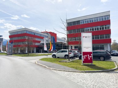 Kırmızı dış ve park alanı olan modern ofis binası.