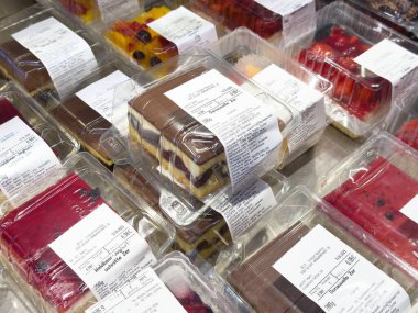 Plastik kaplarda besin etiketleri bulunan çeşitli paketlenmiş hamur işleri.