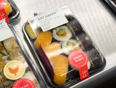 Plastik tepside taze suşi, somon nigiri ve avokado ruloları..