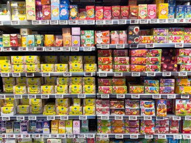 Süpermarket raflarında çeşitli marka ve aromaları gösteren çeşitli bitkisel çay seçimleri.