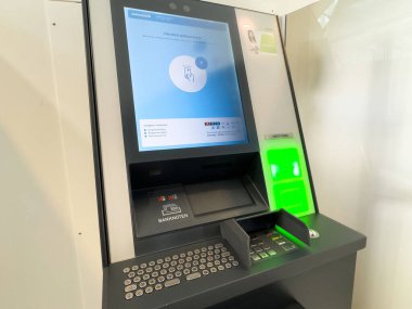 Güvenli bankacılık işlemleri için kart yuvası ve dokunmatik ekranı olan modern ATM makinesi.