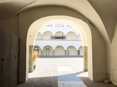 Tarihi Avrupa binasında güneş ışığı avlusu kemerli geçitten geçiyor.