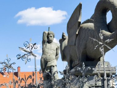 Efsanevi yaratıkların antik taş heykeli ve tarihsel ortamda erkek figürü..