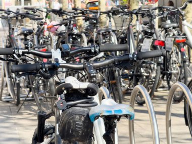 Güneşli bir günde bisiklet parkı çeşitli bisikletlerle dolu..