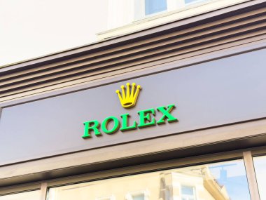 Önünde ikonik yeşil ve altın tabelalı Rolex mağaza dışı.