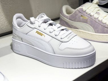 Ayakkabı mağazasında beyaz puma ayakkabıları sergileniyor.