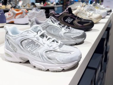 Mağaza rafında çeşitli renklerde gösterilen şık spor ayakkabıları.