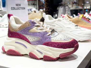 Ayakkabı mağazasında renkli kadın spor ayakkabıları sergileniyor..