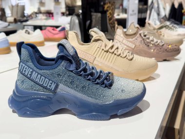 Steve Madden marka spor ayakkabıları: mağaza rafında mavi ve bej ayakkabılar.
