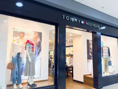 Tommy Hilfiger moda mankenleri ve kıyafetleriyle vitrin vitrininde.