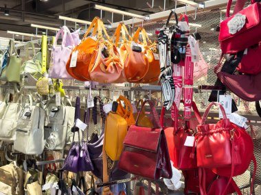 Değişik stil ve dokulara sahip bir moda mağazasında sergilenen renkli çantalar.