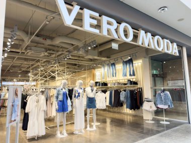 Çağdaş moda mağazalarının vitrinlerinde mankenler gündelik giysiler sergiliyor..